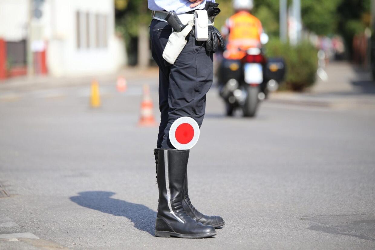 motociclista che guida con casco non allacciato, con pneumatici non omologati e con telefono in mano