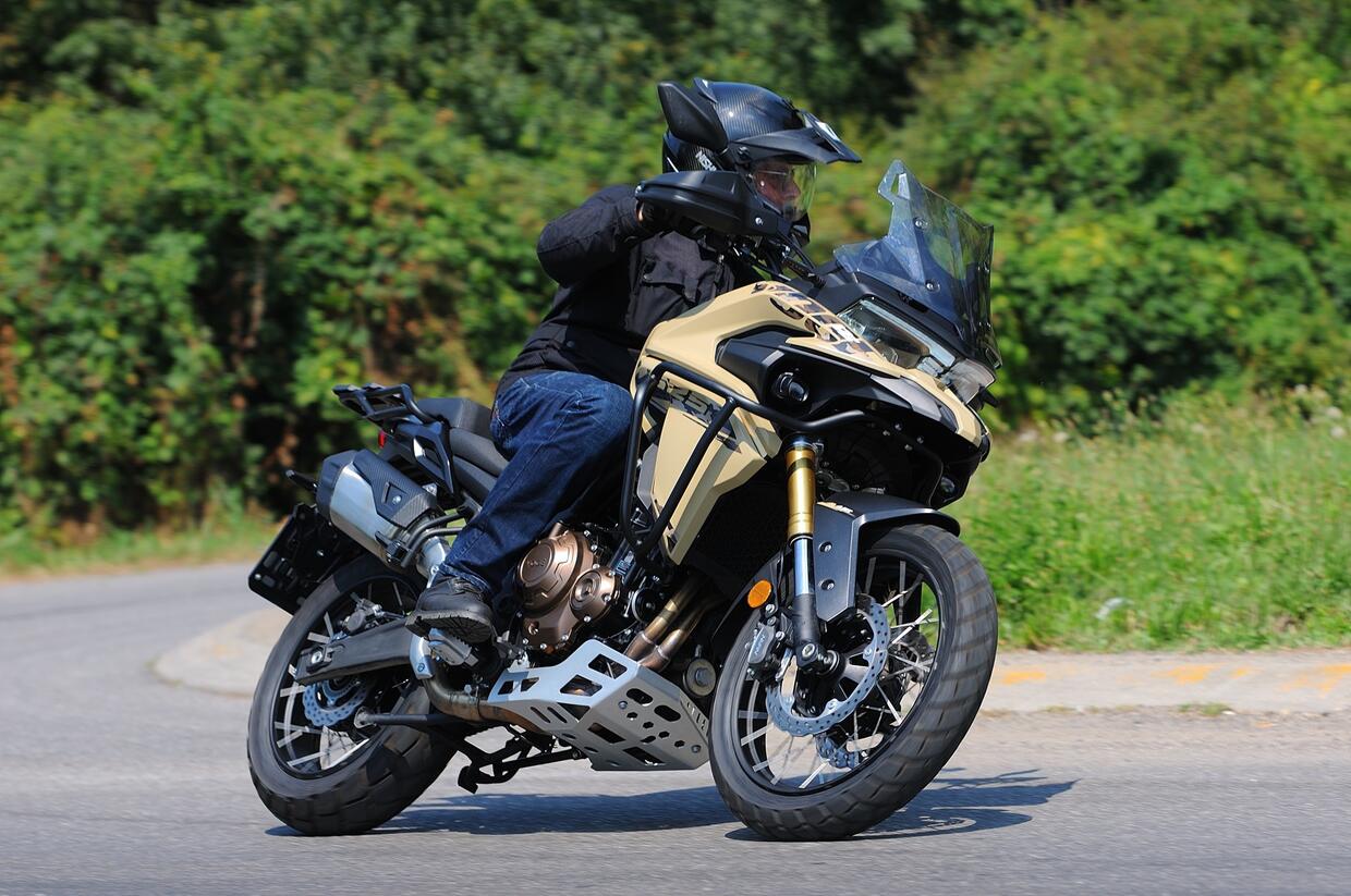 Una moto crossover con telaio in acciaio, sospensioni regolabili e dotazioni moderne, in posizione di guida comoda